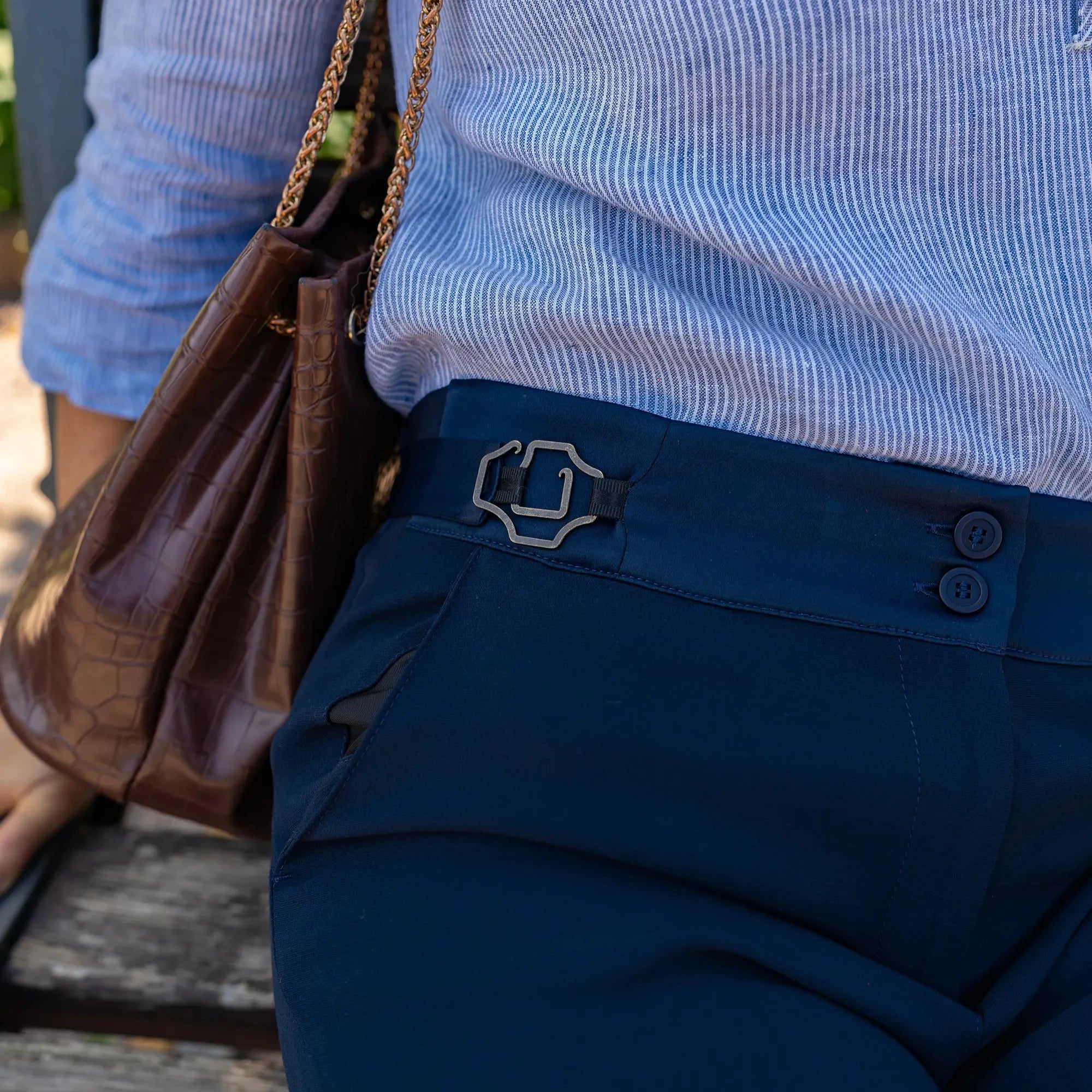 Zoom sur les boucles ajustables, La Justine, modèle baroque laiton vieilli permettant de resserrer la taille du pantalon, création Asur.